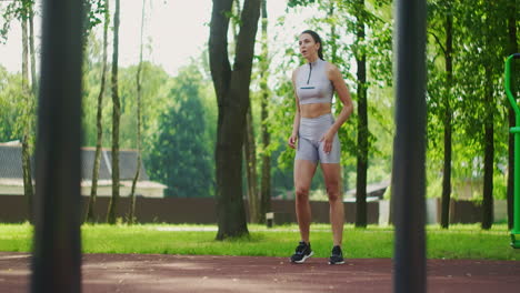 Female-athlete-performs-side-lunges-work-out-her-legs-and-jumping-in-the-Park-in-slow-motion.-Beautiful-woman-playing-sports-in-the-Park.